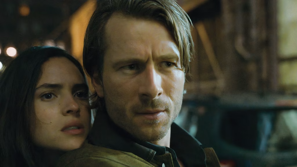 glen-powell-as-gary-johnson-pointing-a-weapon-at-madison-s-ex-in-the-movie-hit-man