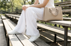 Alt: Person in white outfit sitting on bench