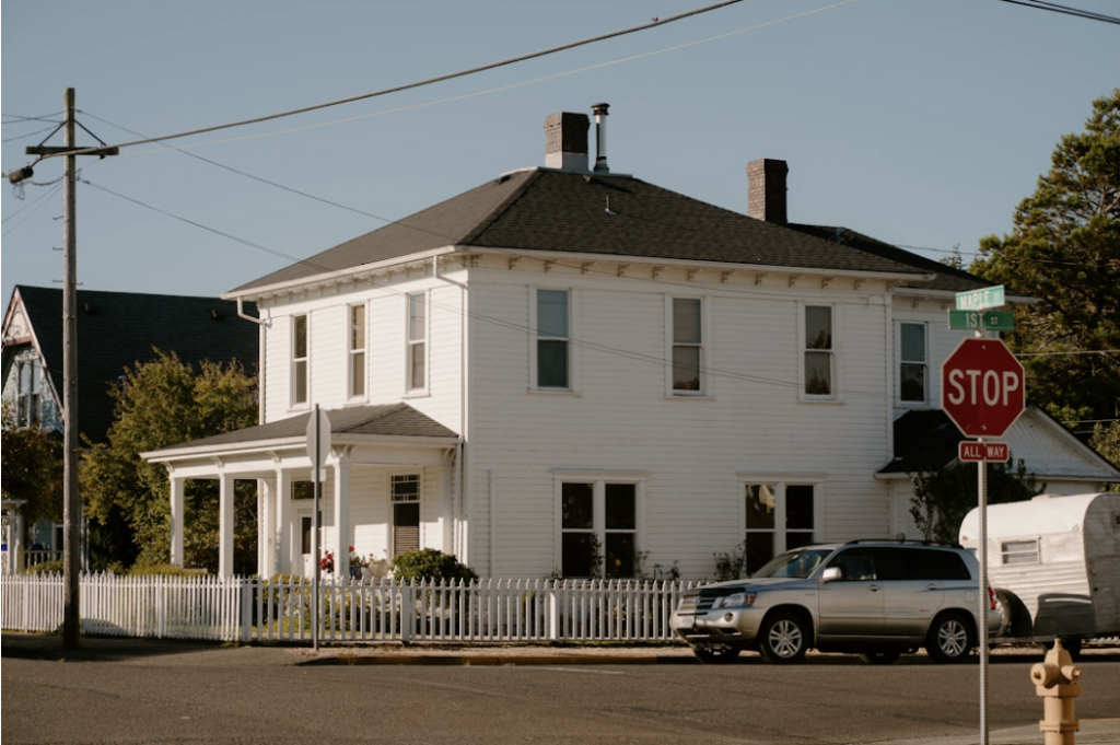 A midwestern clapboard house with a wide porch on a quiet street
